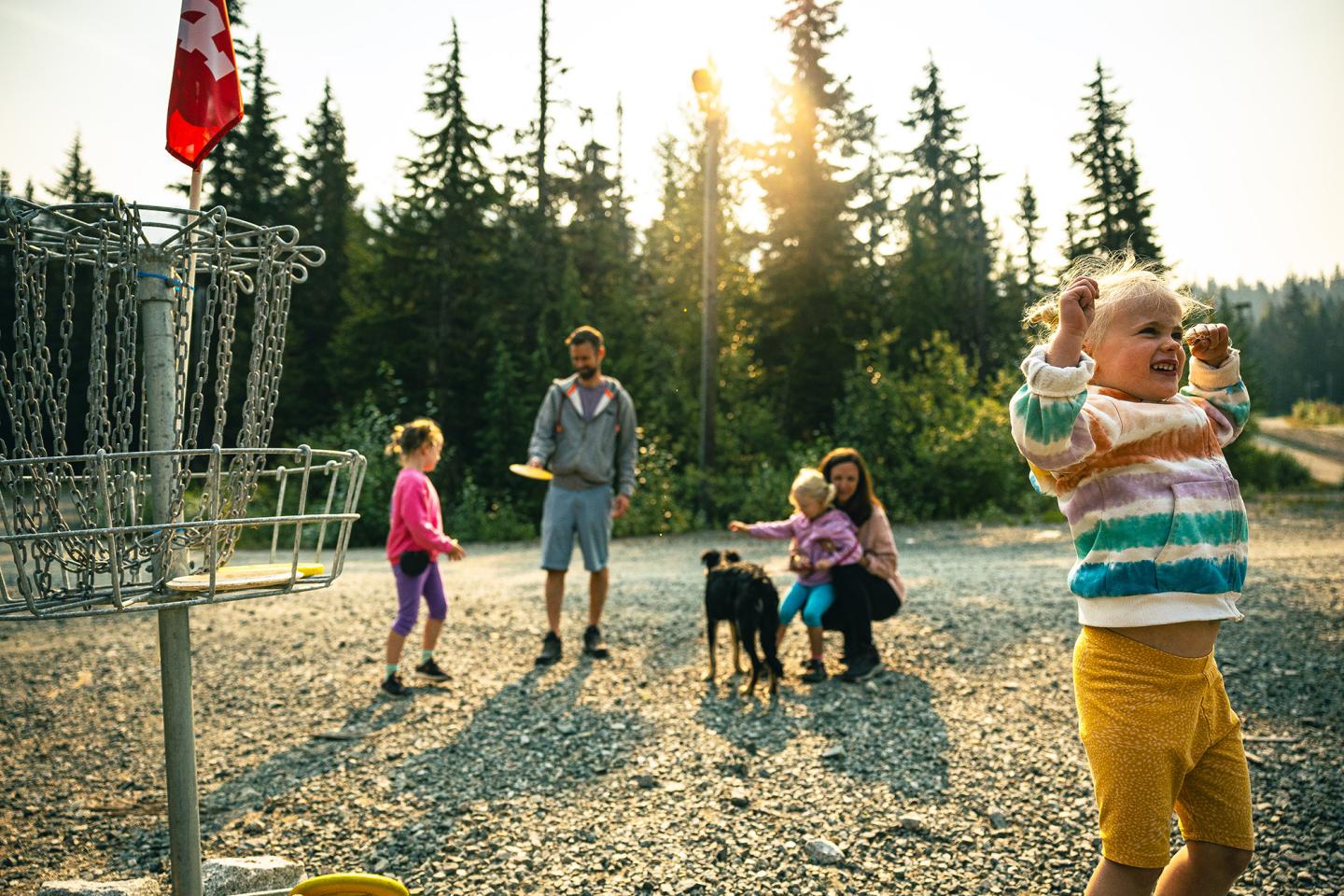 family playing disc golf in the mountains