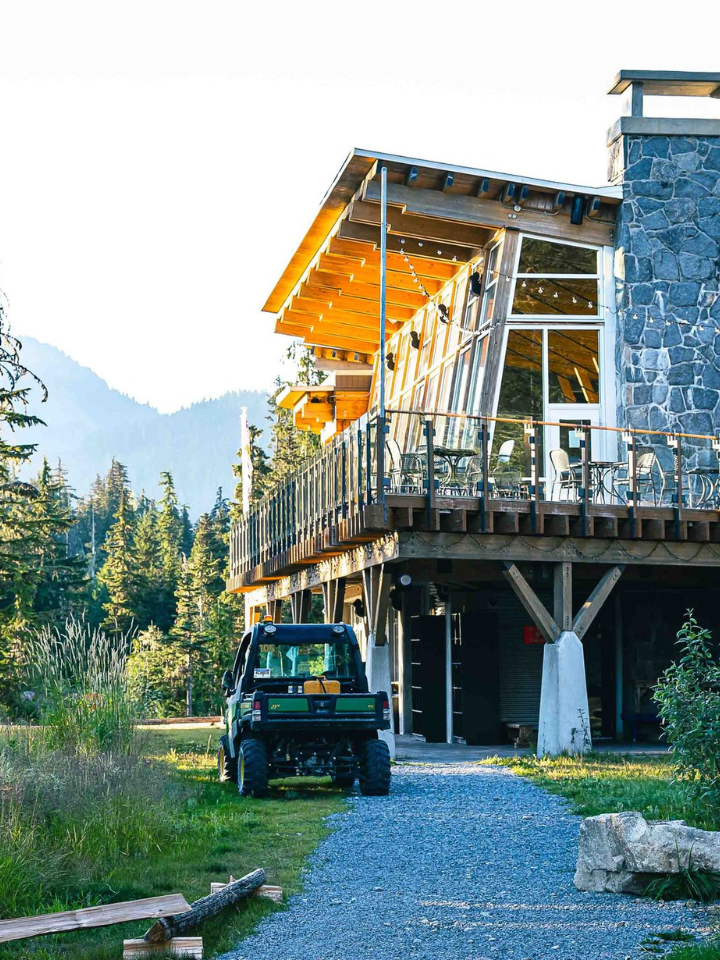 Whistler Olympic park day Lodge , surrounded by trees and mountains.